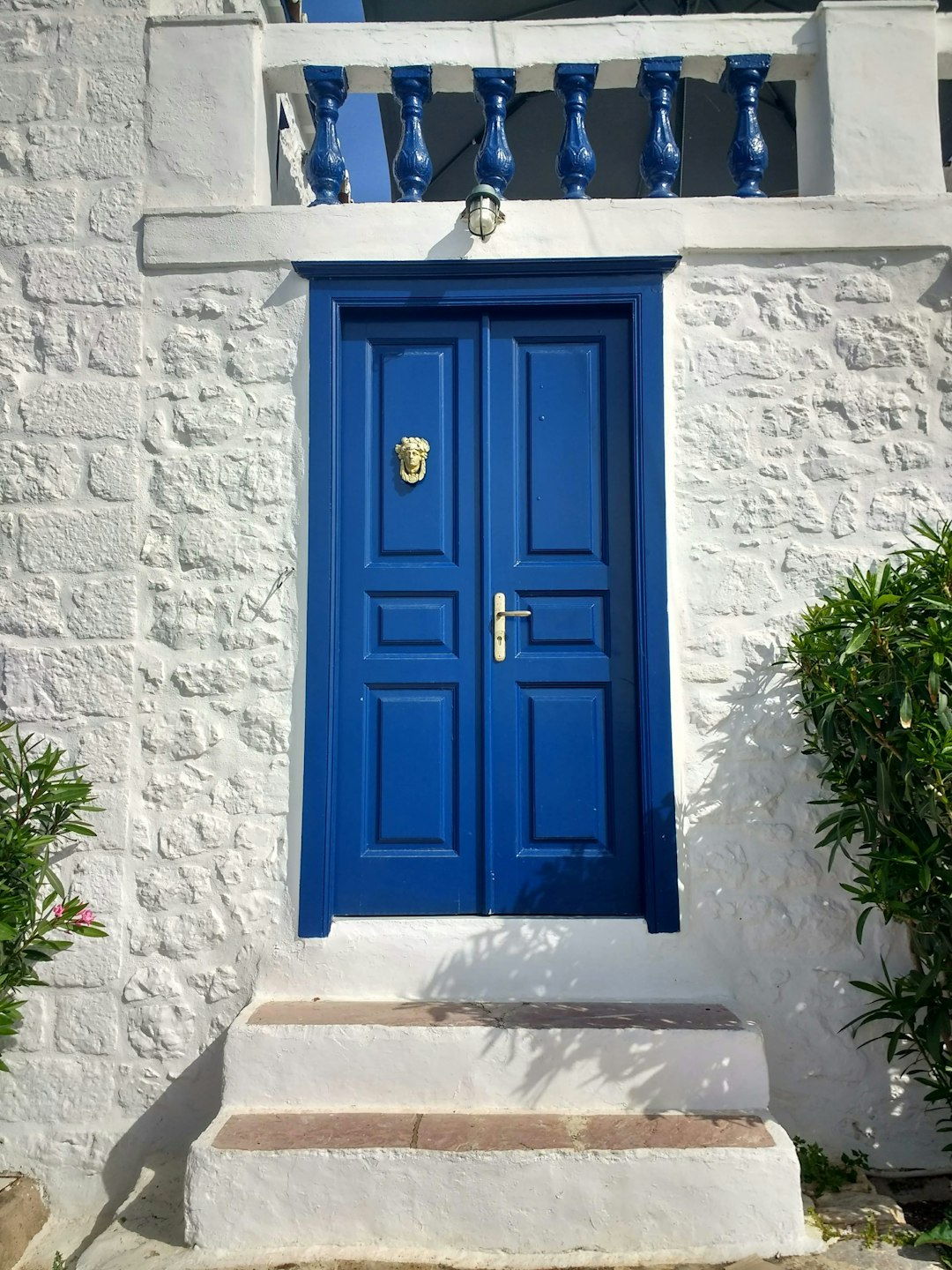 Blaue Tür an weißer griechischer Hauswand