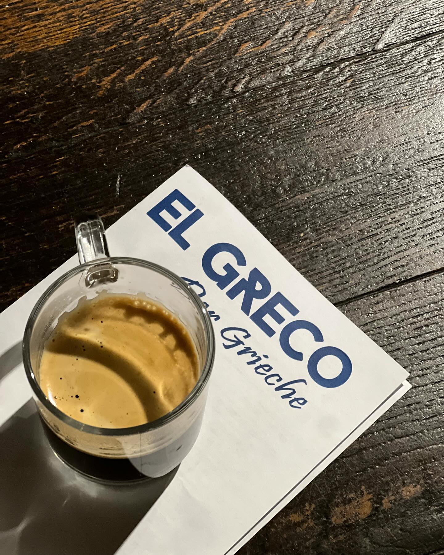 Espresso und Speisekarte auf dunklem Holztisch