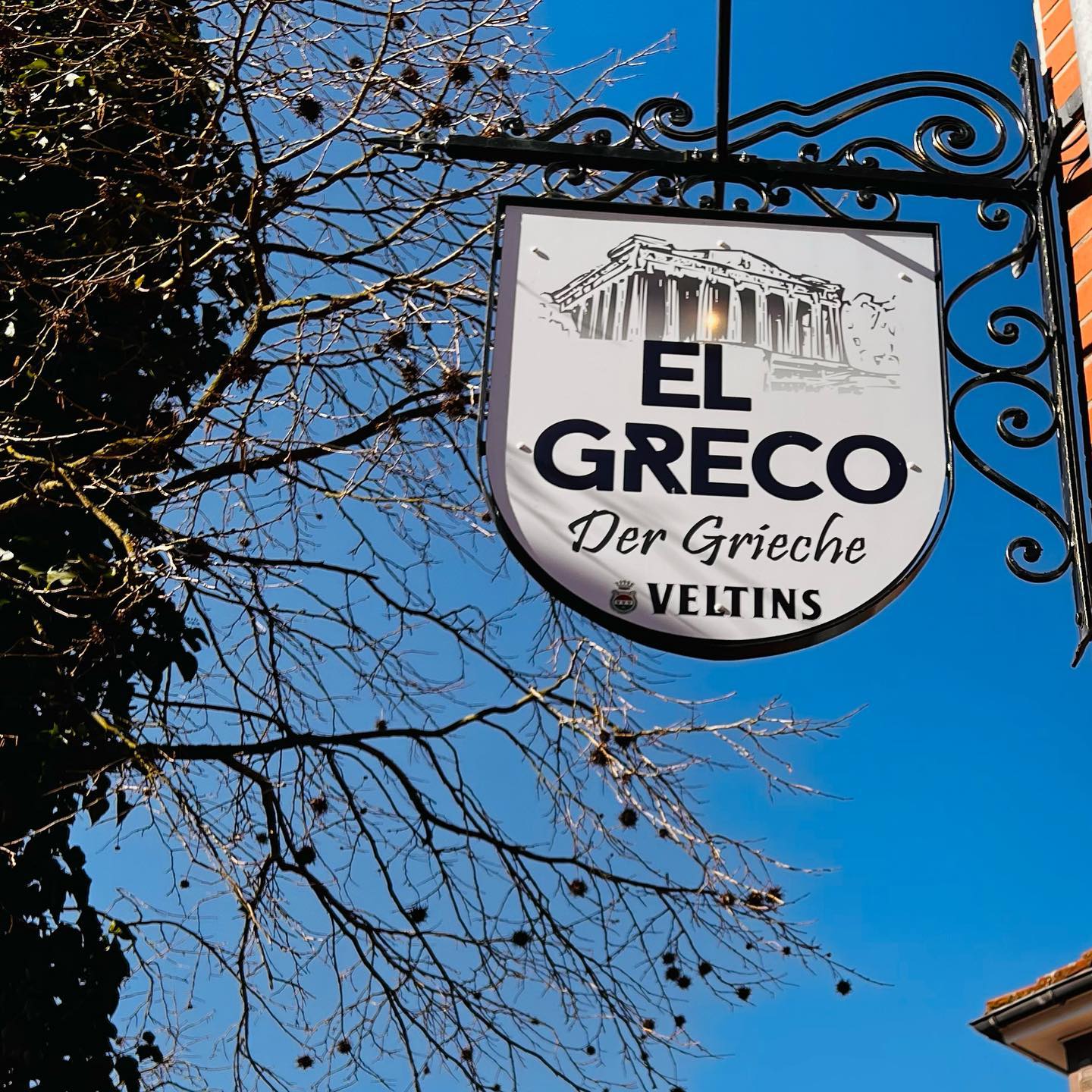 Das hängende Restaurantschild vor blauem Himmel